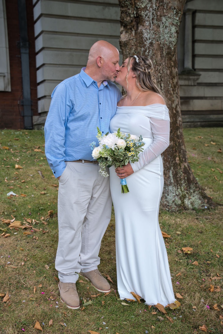 Bride and groom kiss after just getting married on the on the grounds of Stockport Townhall.